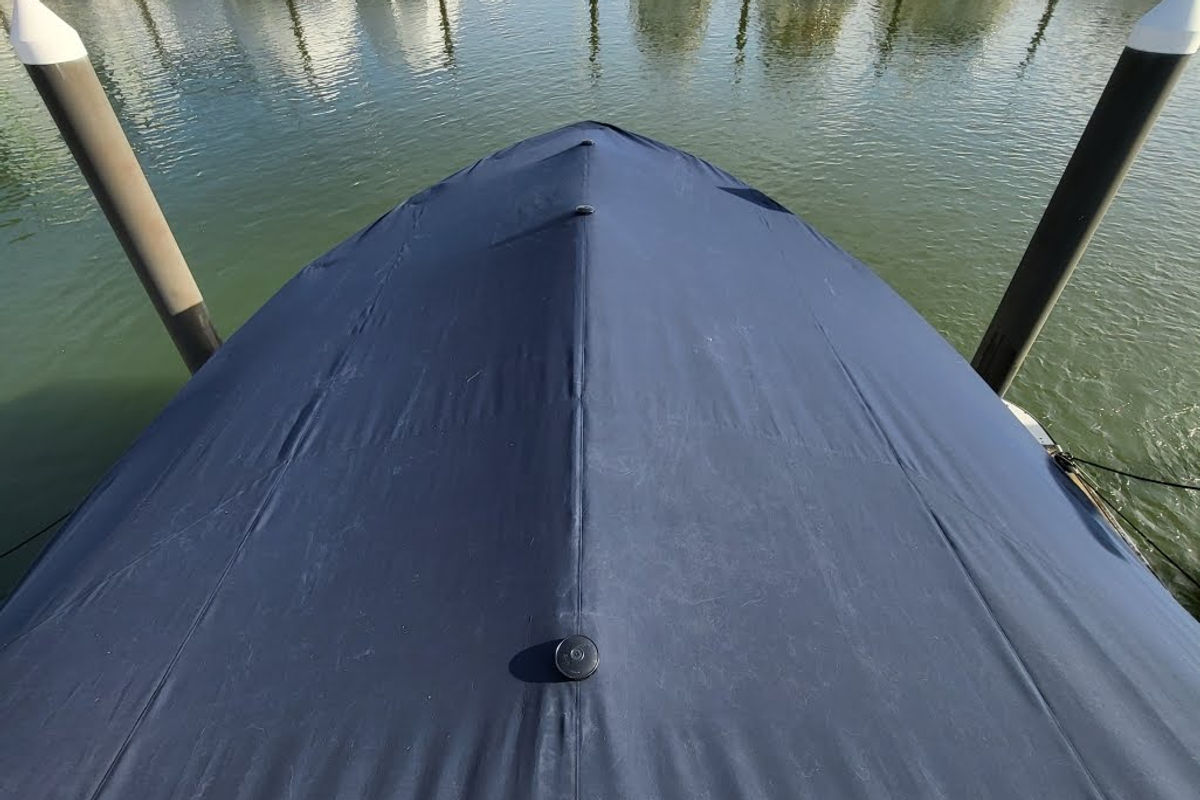 Fitted dark canvas cover over a boat bow