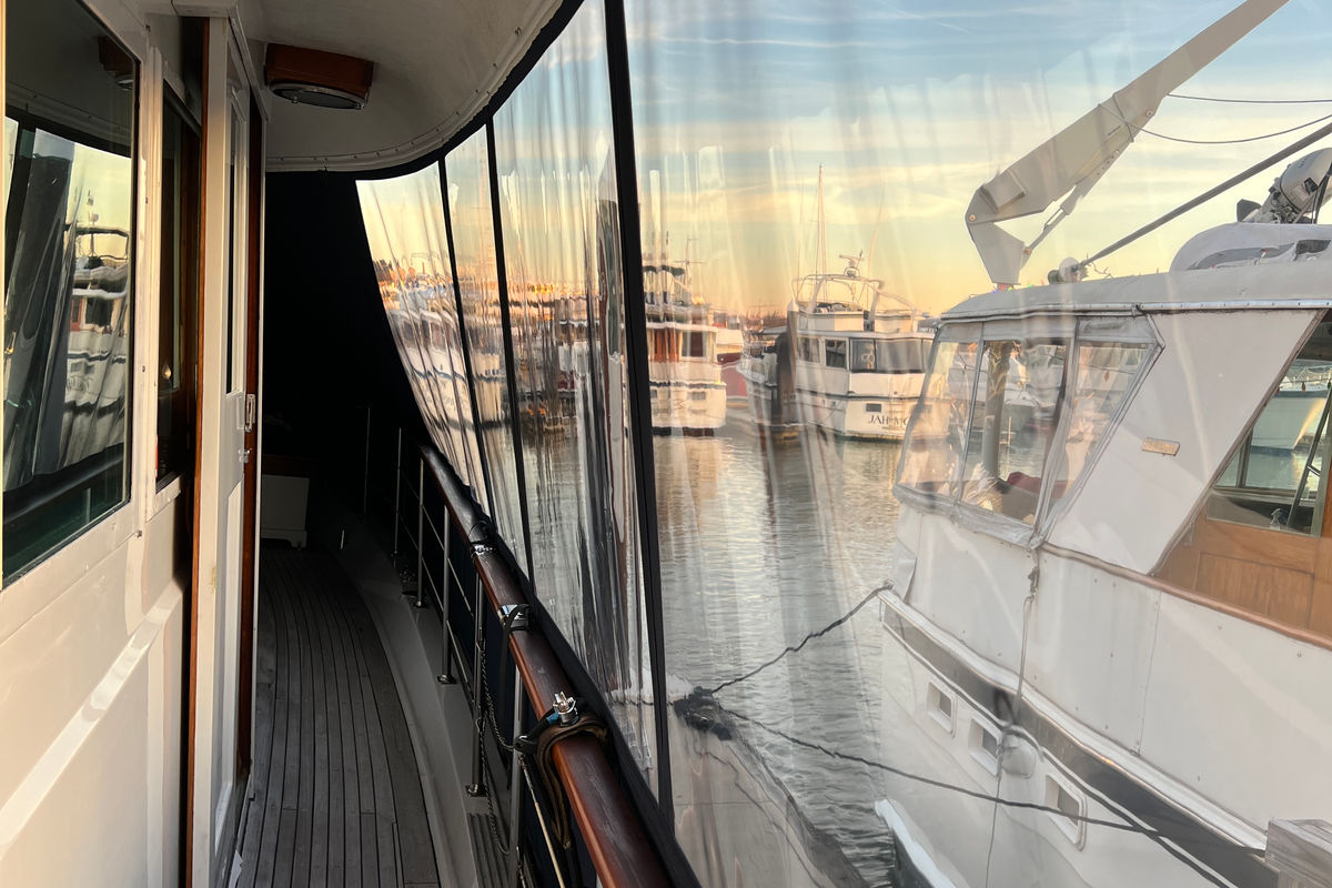 Clear vinyl side enclosure along a teak deck